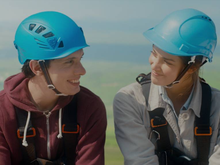Luna (Laura Berlin) und Lionel (Anthony Jeanne) mit blauen Helmen auf dem Kopf