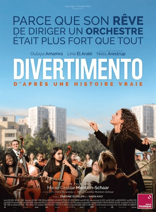 Filmplakat von Divertimento. Eine Frau dirigiert ein Orchester im Freien. Im Hintergrund sind hohe Gebäude und ein paar Bäume zu sehen.