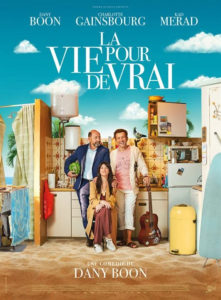 Bildbeschreibung: Filmplakat "La vie pour de vrai". Zwei Männer und eine Frau stehen vor einer Küche, die an einem Stand aufgebaut ist.