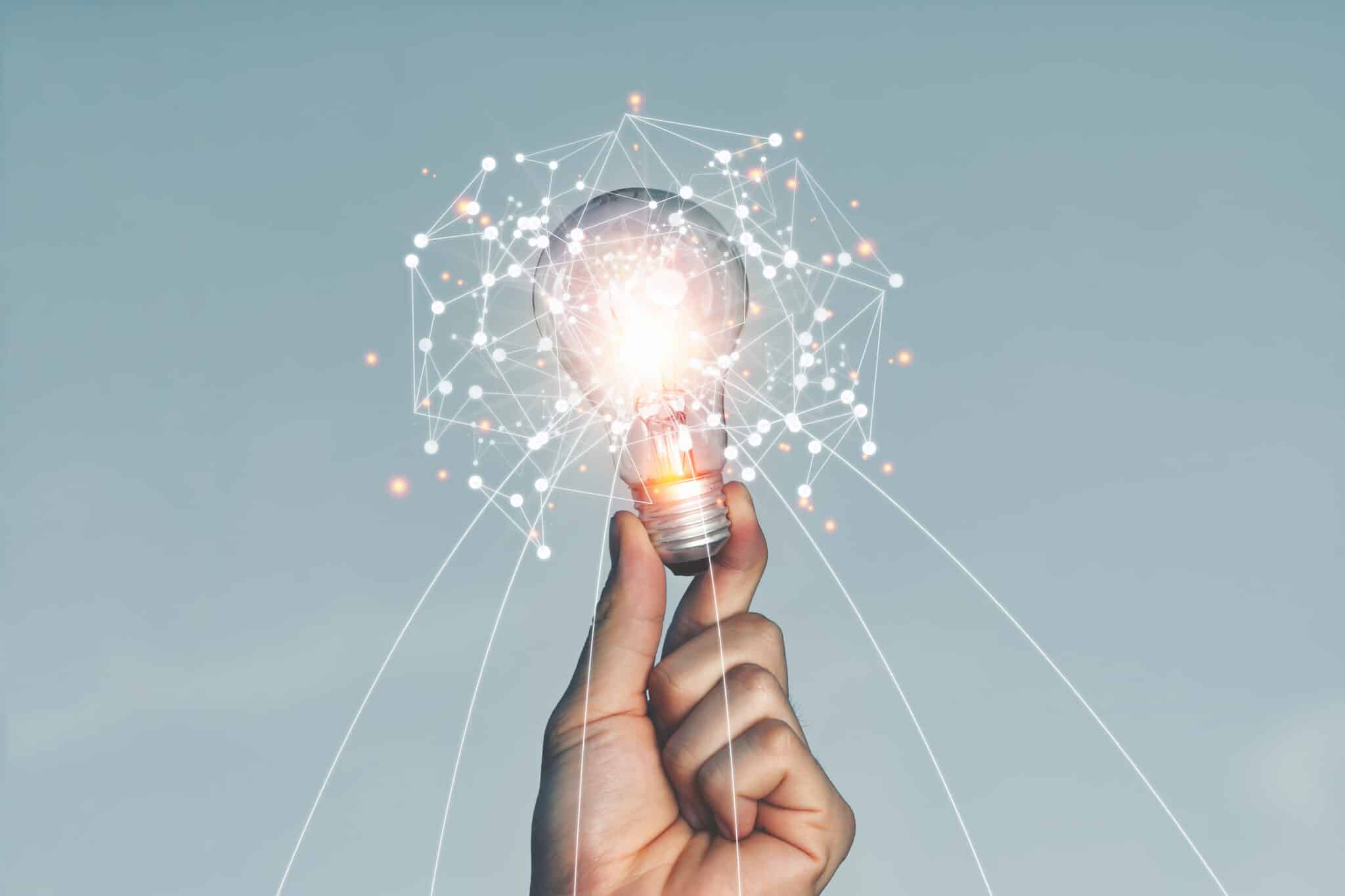 A hand holding a light bulb Lifted up in the sky outdoors With the idea of creating new ideas (Bild: Aon Khanisorn/ AdobeStock_357126154)