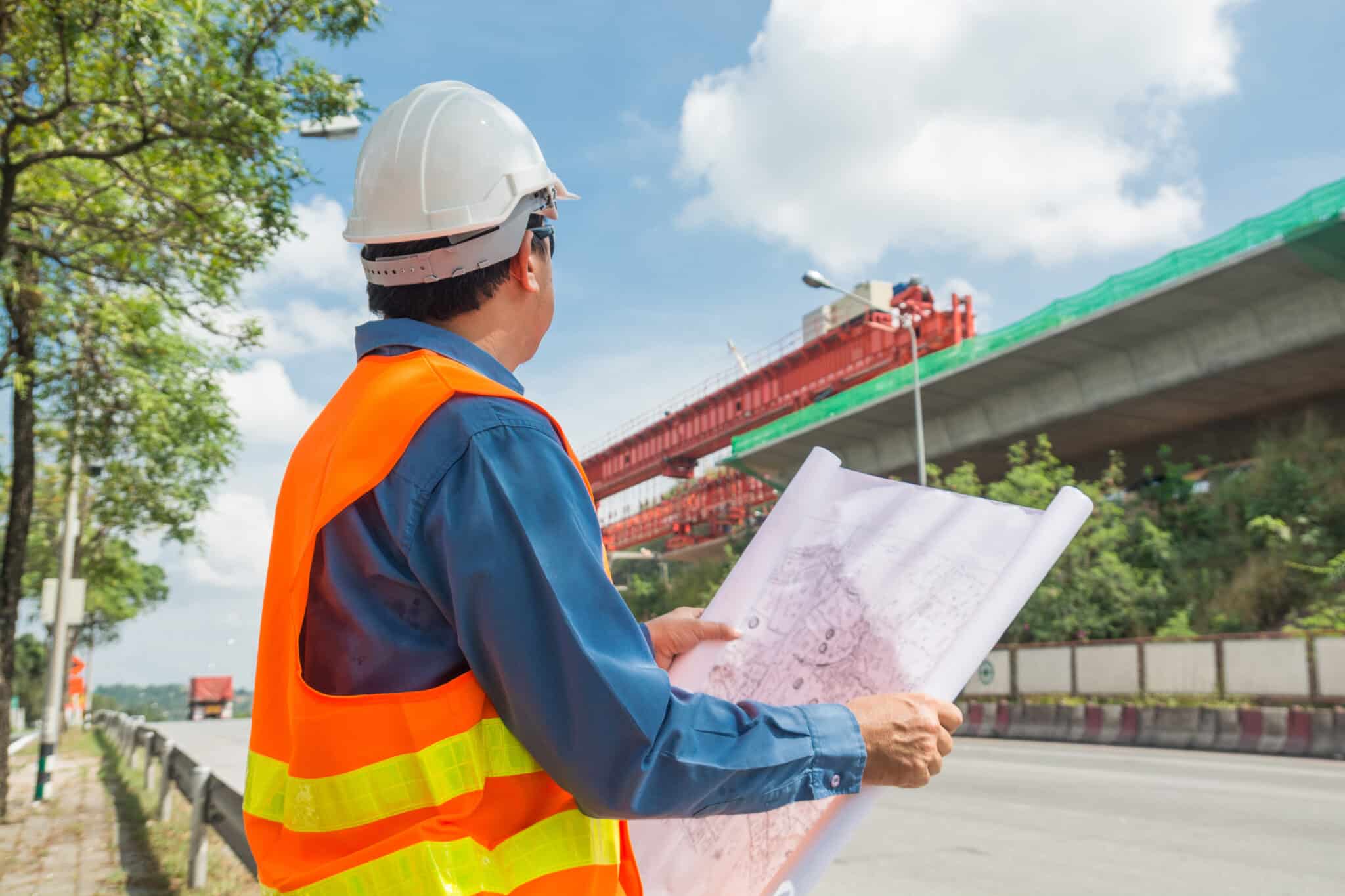 Engineer or Architect wear white Helmet working or reading Construction Plan (Foto: AdobeStock_234254968/ thampapon1)